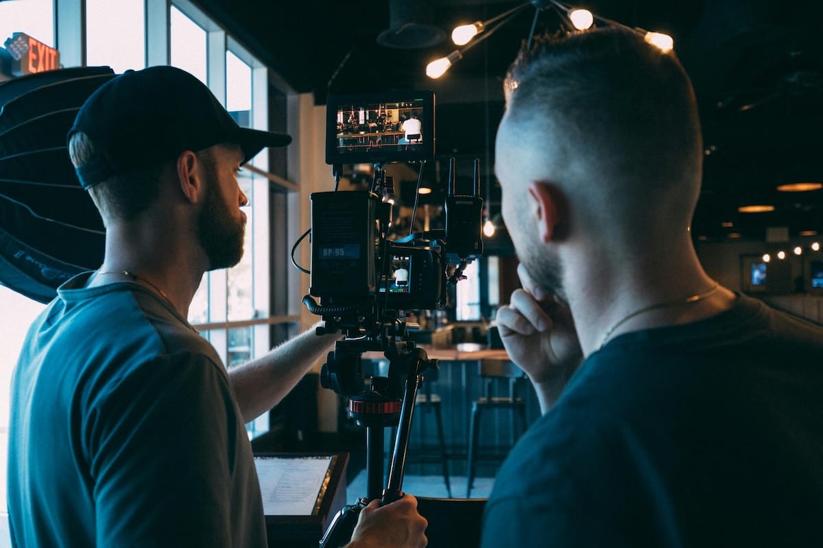 Two crew members from Best Footage Productions setting up a camera on location for a shoot.